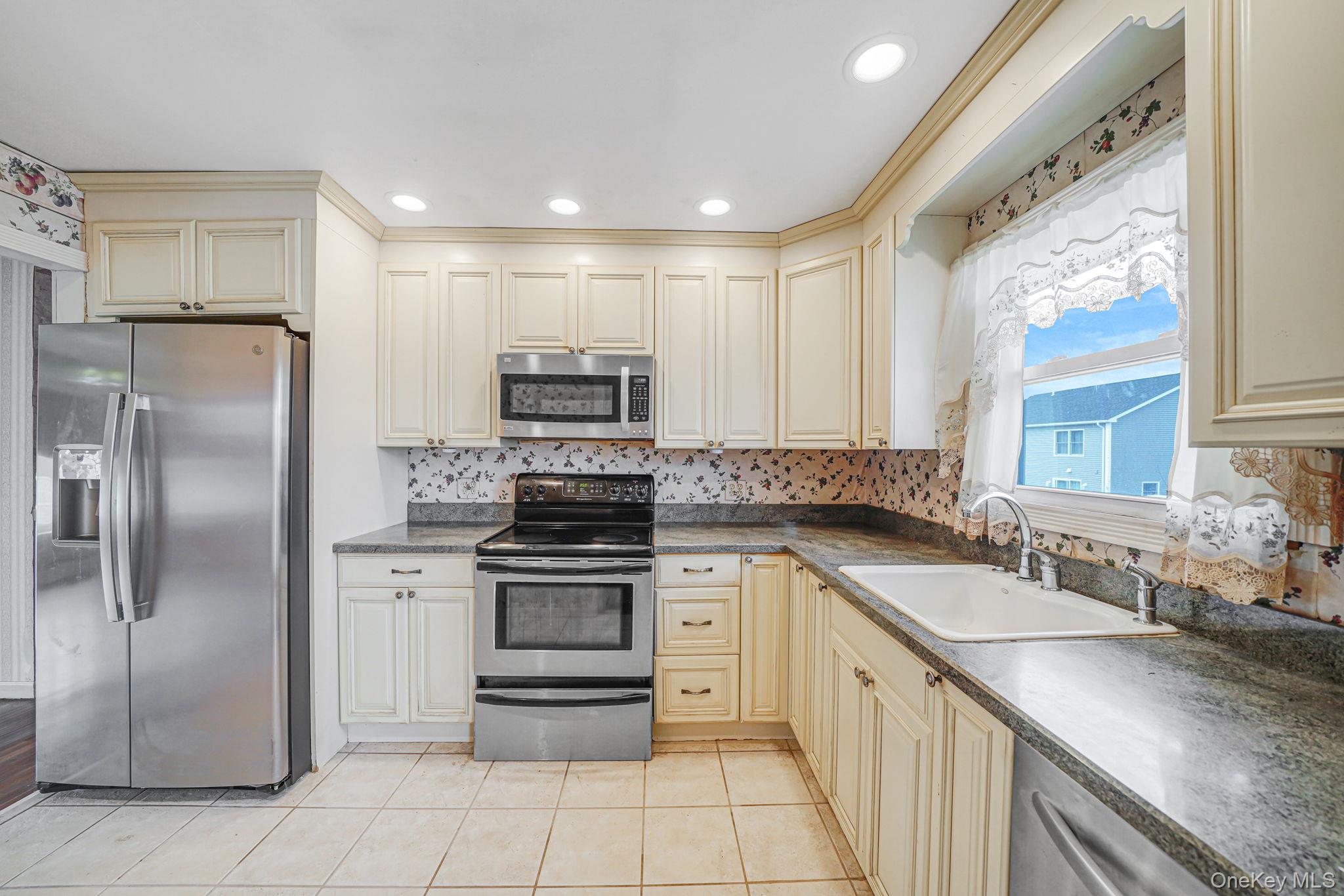 501 Windmill Avenue West Babylon, NY 11704 - Photo 14 of 35 a kitchen with stainless steel appliances granite countertop a sink stove and refrigerator