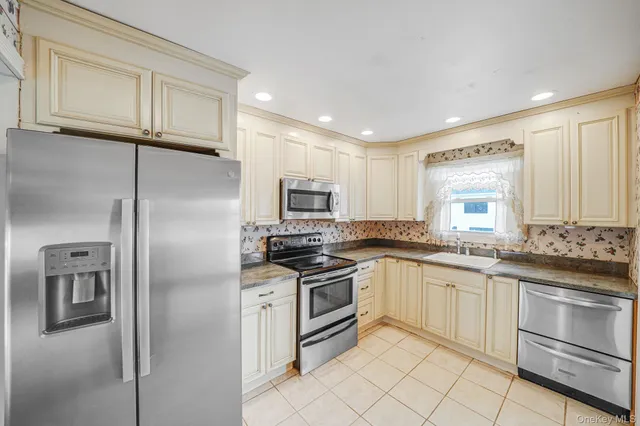 a kitchen with stainless steel appliances granite countertop a refrigerator and a stove top oven