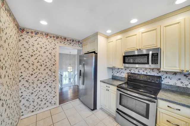 a kitchen with stainless steel appliances granite countertop a refrigerator and a stove top oven