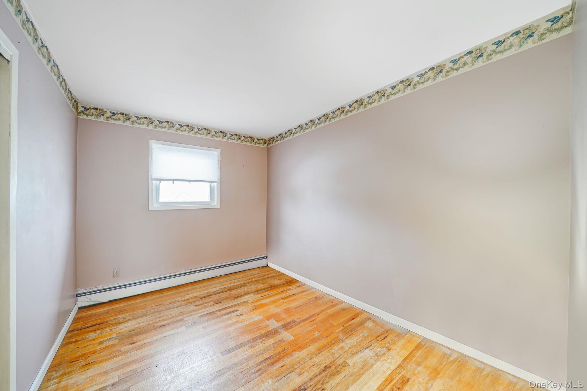 501 Windmill Avenue West Babylon, NY 11704 - Photo 22 of 35 a view of a room with wooden floor and white walls