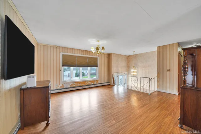 a view of a kitchen with wooden floor and a flat screen tv