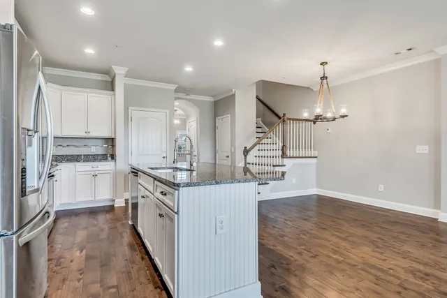 a kitchen with stainless steel appliances a stove top oven a refrigerator a sink and dishwasher