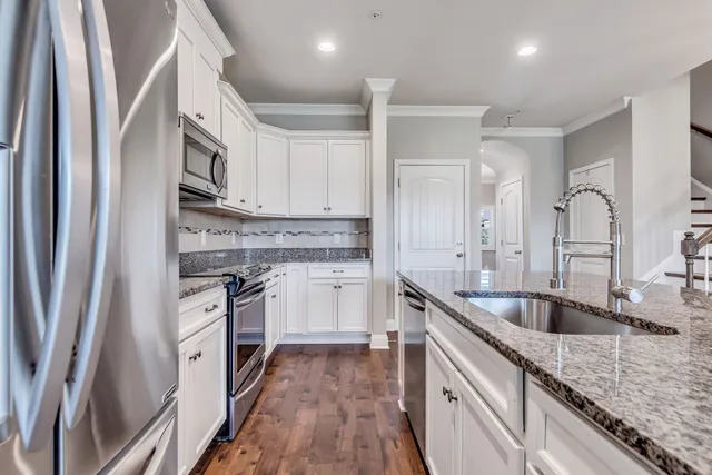 a kitchen with stainless steel appliances granite countertop a sink stove and refrigerator