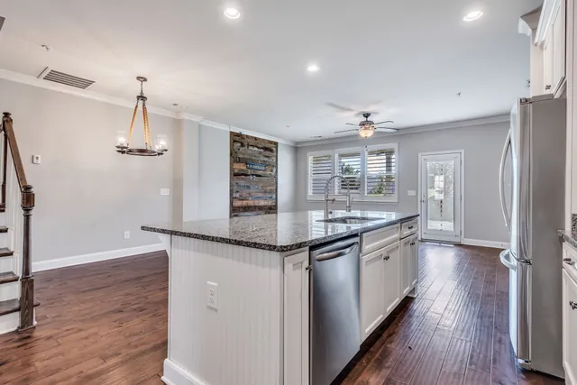 a kitchen with stainless steel appliances granite countertop a sink and refrigerator