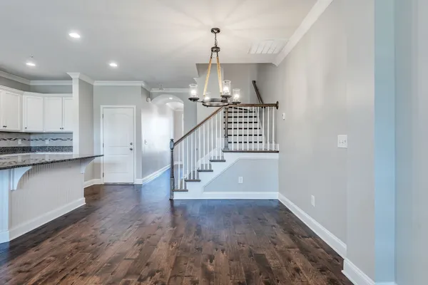 a view of entryway and kitchen with wooden floor