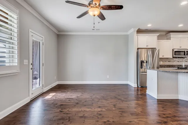 a view of a kitchen with a sink refrigerator and wooden floor