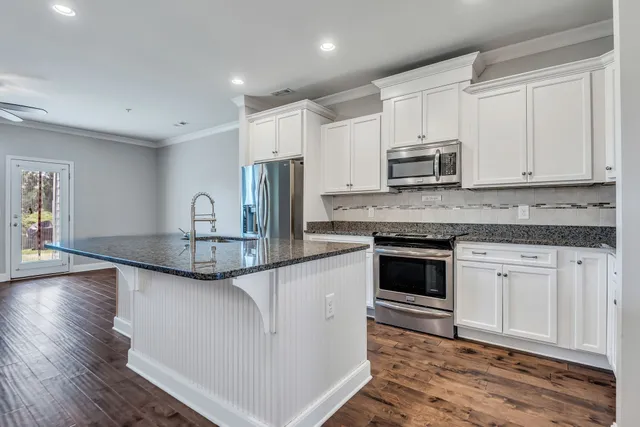 a kitchen with stainless steel appliances granite countertop a sink and cabinets