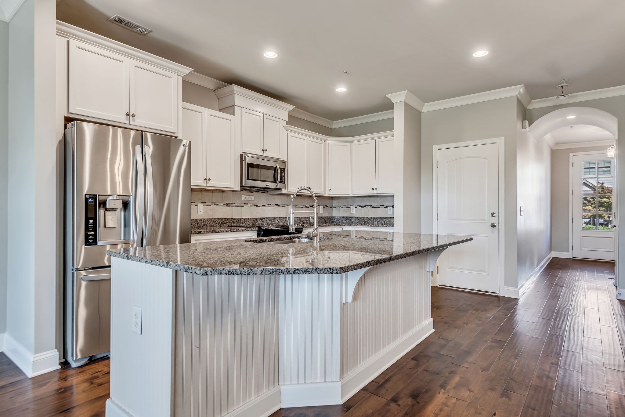1477 Channing Drive Thompson's Station, TN 37179 - Photo 10 of 33 a kitchen with stainless steel appliances granite countertop a refrigerator a stove a sink and white cabinets with wooden floor
