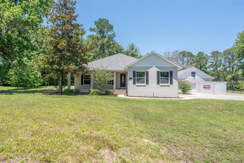 4735 Southeast 112th Street Road Belleview, FL 34420 - Photo 3 of 73 a front view of a house with a garden