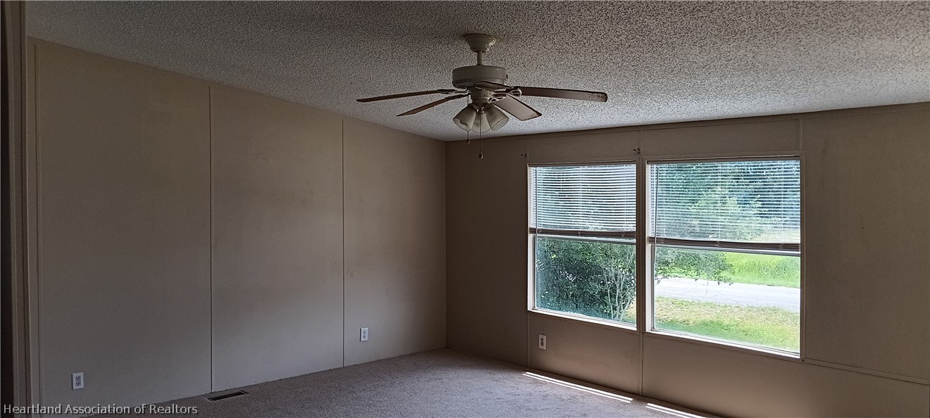 1026 Cardinal Road Wauchula, FL 33873 - Photo 7 of 12 an empty room with windows and ceiling fan