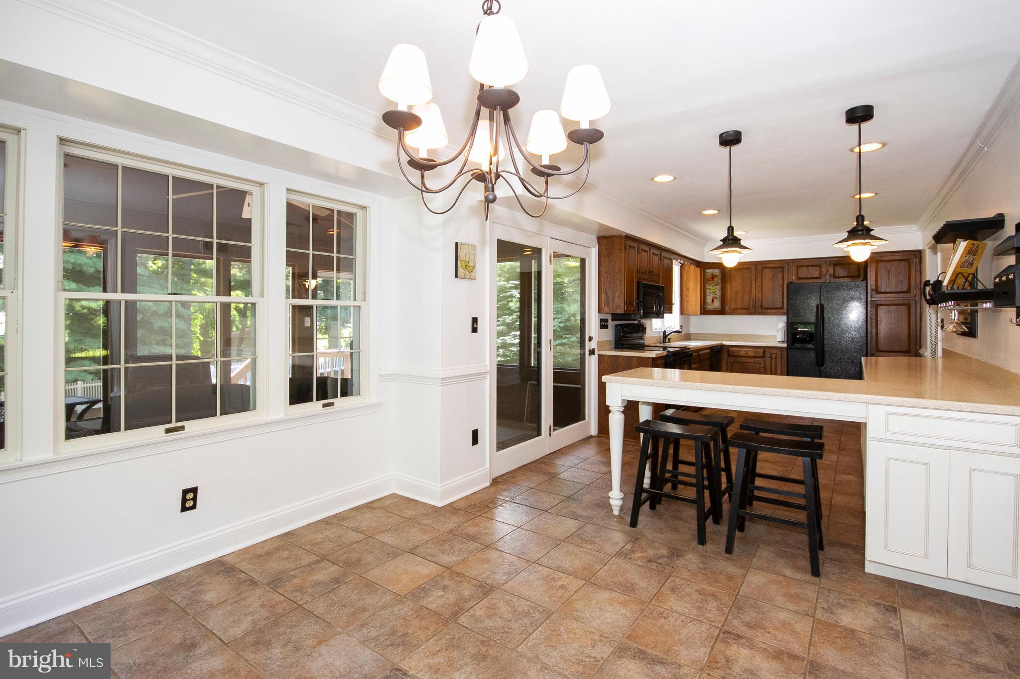 1907 Springview Court Fallston, MD 21047 - Photo 15 of 30 a kitchen with kitchen island a dining table chairs and a chandelier