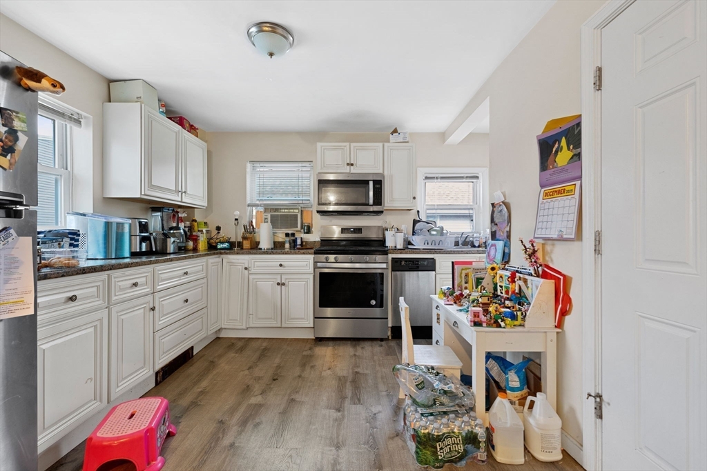 19 Alfred Street, Unit 2 Everett, MA 02149 - Photo 5 of 14 a kitchen with granite countertop a stove and cabinets