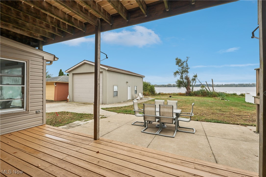 337 Cedar Point Road Sandusky, OH 44870 - Photo 35 of 50 Wooden terrace featuring an outdoor structure, a patio area, a water view, a yard, and a garage