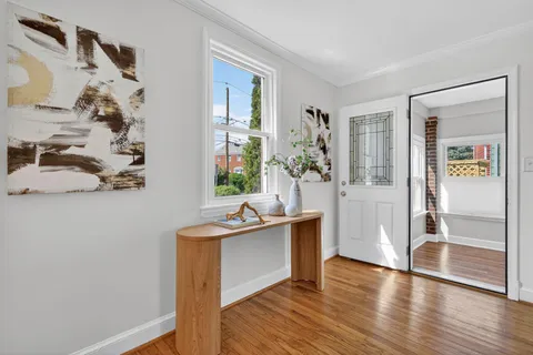 a view of a kitchen and an entryway with wooden floor