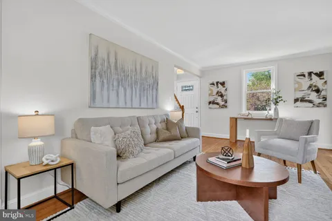 a living room with furniture a rug and a lamp