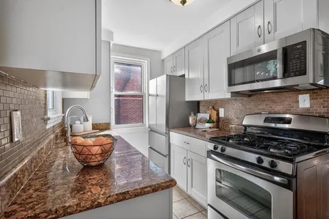 a kitchen with stainless steel appliances granite countertop a stove a sink and a microwave