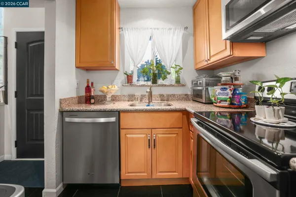 a kitchen with stainless steel appliances granite countertop a sink stove and cabinets