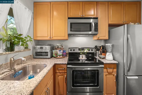 a kitchen with stainless steel appliances granite countertop a sink stove and microwave
