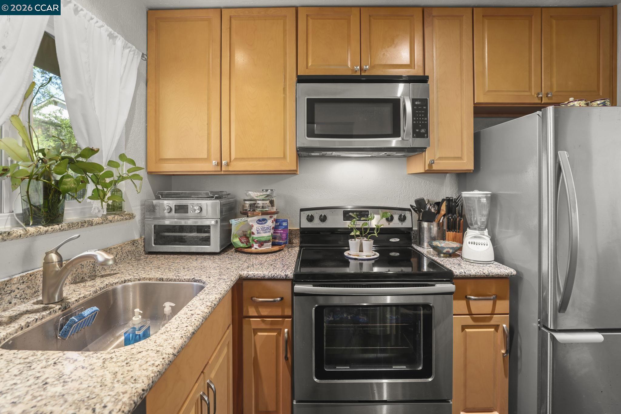 61 Meadowbrook Circle Pittsburg, CA 94565 - Photo 12 of 24 a kitchen with stainless steel appliances granite countertop a sink stove and microwave