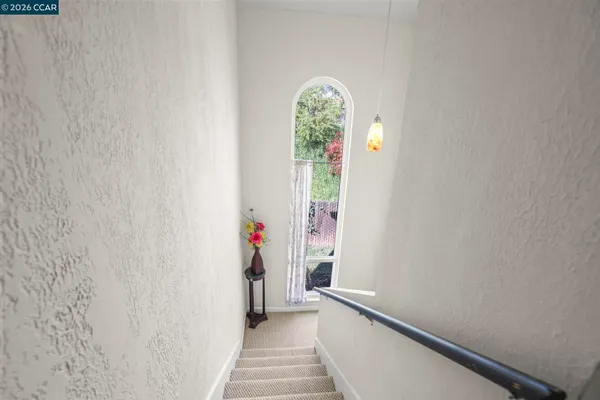 a view of a hallway with wooden floor and a bathroom