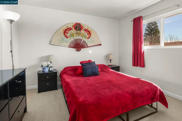 a large bed sitting in a bedroom next to a window