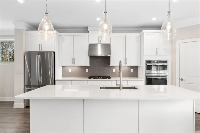 a kitchen with granite countertop white cabinets and stainless steel appliances