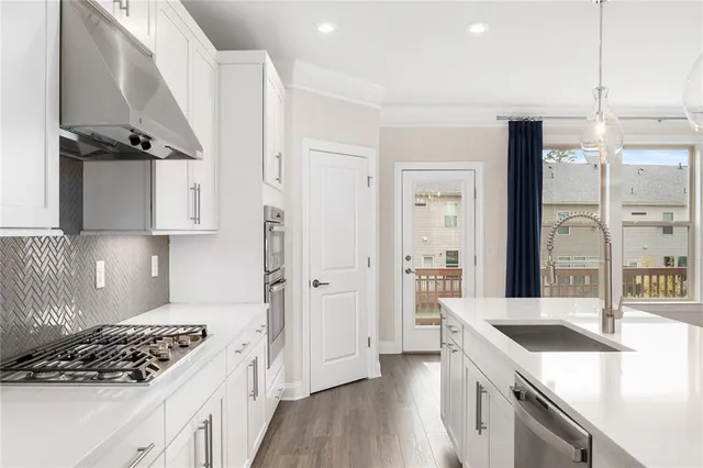 a kitchen with stainless steel appliances granite countertop a sink stove and refrigerator