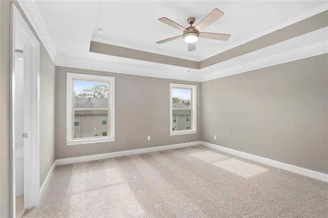 a view of an empty room and chandelier fan
