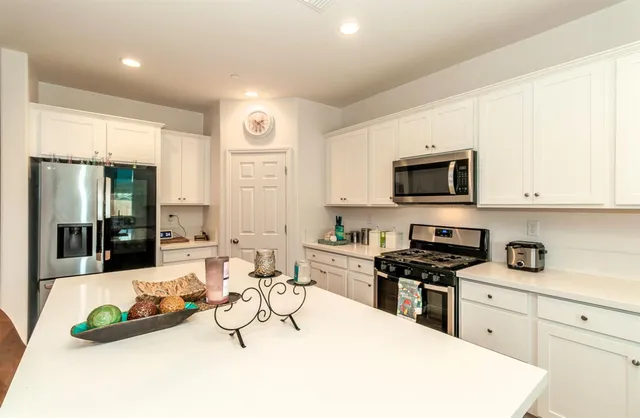 a kitchen with stainless steel appliances kitchen island granite countertop a sink and cabinets