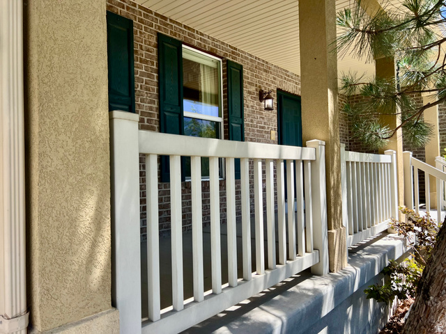 369 Culross Circle Tooele, UT 84074 - Photo 53 of 54 Expansive front porch featuring white railing, textured stucco columns, brick facade, and dark green louvered shutters