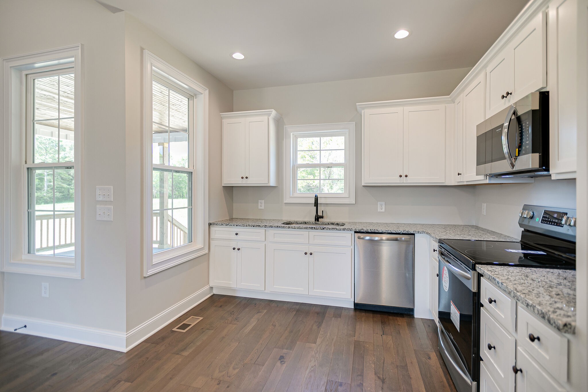 4640 Lunns Store Road Chapel Hill, TN 37034 - Photo 12 of 30 a kitchen with granite countertop white cabinets a sink a window a wooden floor and stainless steel appliances