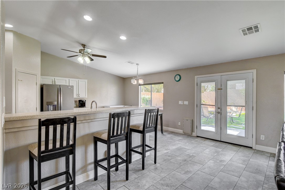 910 Cobblestone Cove Road North Las Vegas, NV 89081 - Photo 5 of 30 A breakfast bar offers casual dining, complemented by direct access to the private yard through glass doors.