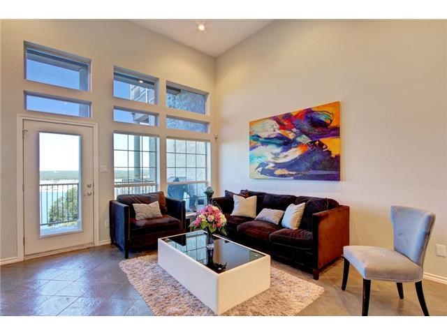 2918 Ranch Road 620, Unit K170 Austin, TX 78734 - Photo 2 of 22 A spacious living area with soaring ceilings and floor-to-ceiling windows offering expansive water views.