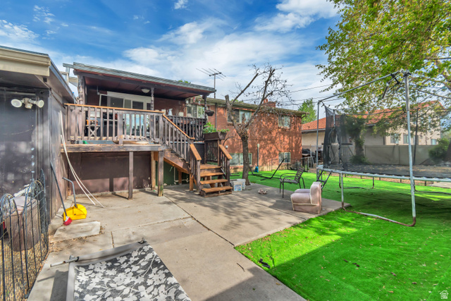 7470 Ramanee Drive Midvale, UT 84047 - Photo 26 of 29 Rear view of property with a trampoline, a deck, and a patio area
