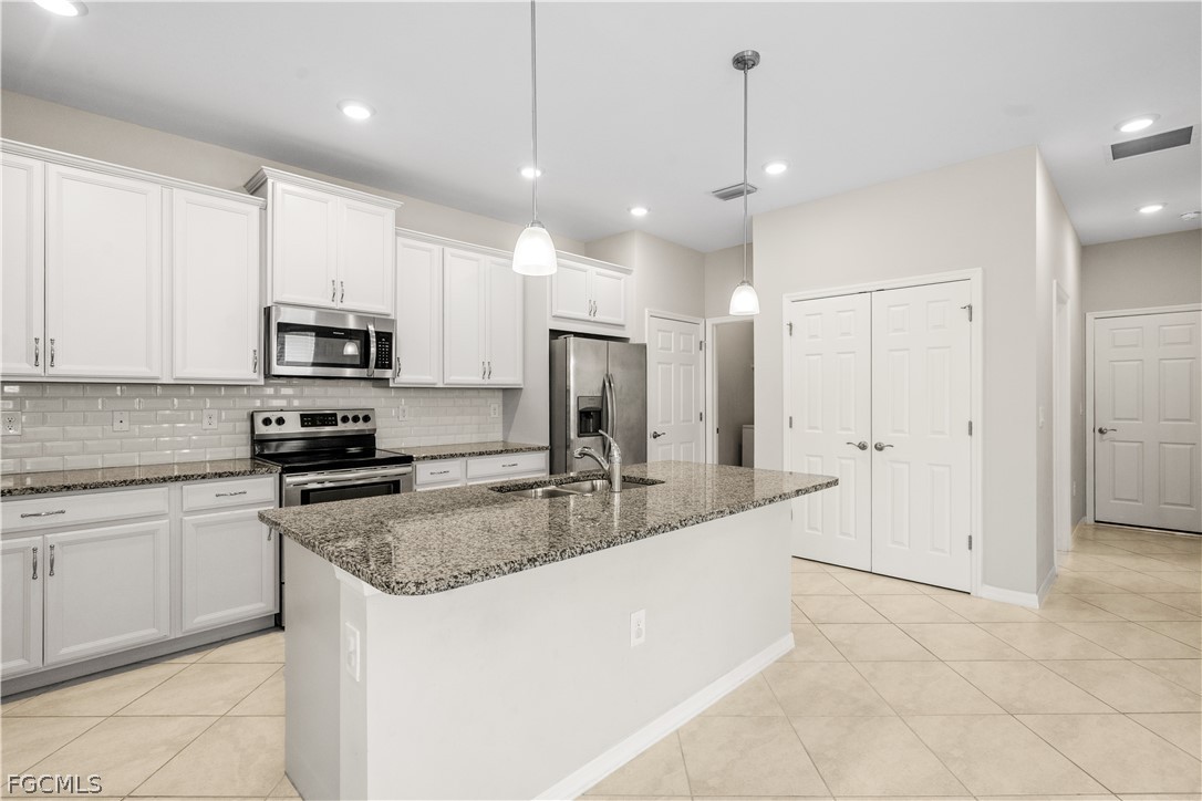 4443 Dutchess Park Road Fort Myers, FL 33916 - Photo 7 of 19 a large kitchen with granite countertop a sink a counter top space appliances and cabinets