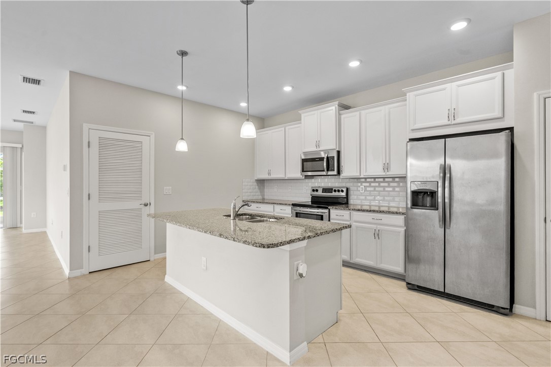 4443 Dutchess Park Road Fort Myers, FL 33916 - Photo 8 of 19 a kitchen with kitchen island white cabinets stainless steel appliances and a sink