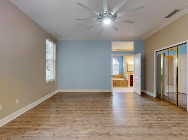a view of an empty room with window and wooden floor
