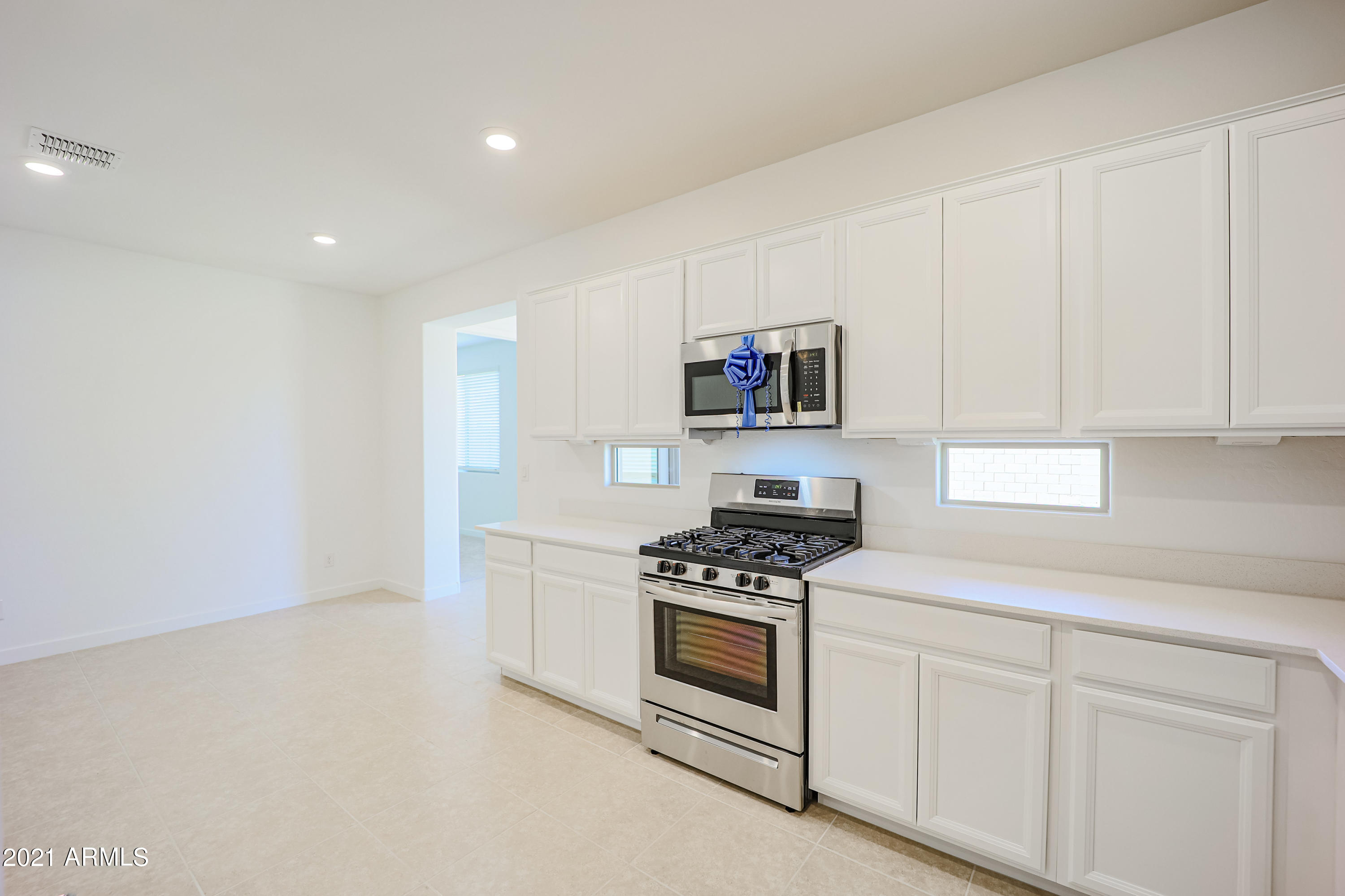 16556 West Alameda Road Surprise, AZ 85387 - Photo 12 of 34 a kitchen with white cabinets and white appliances