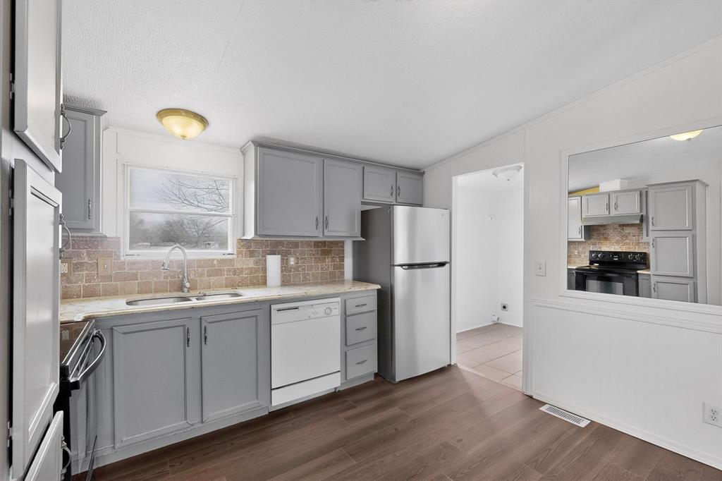 6553 Private Road 2270 Quinlan, TX 75474 - Photo 5 of 31 Kitchen featuring gray cabinetry, tasteful backsplash, stainless steel appliances, and vaulted ceiling