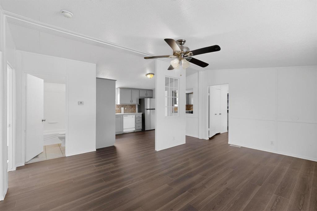 6553 Private Road 2270 Quinlan, TX 75474 - Photo 8 of 31 Unfurnished living room featuring ceiling fan, dark wood-style flooring, and vaulted ceiling