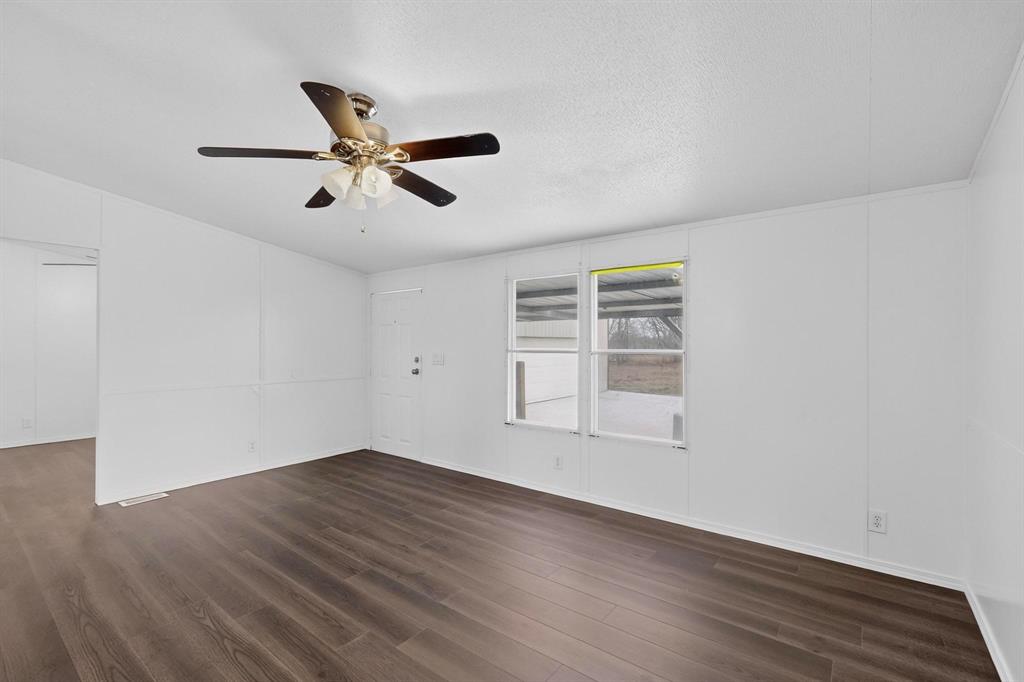 6553 Private Road 2270 Quinlan, TX 75474 - Photo 9 of 31 Unfurnished room with dark wood-style flooring, ceiling fan, and a textured ceiling
