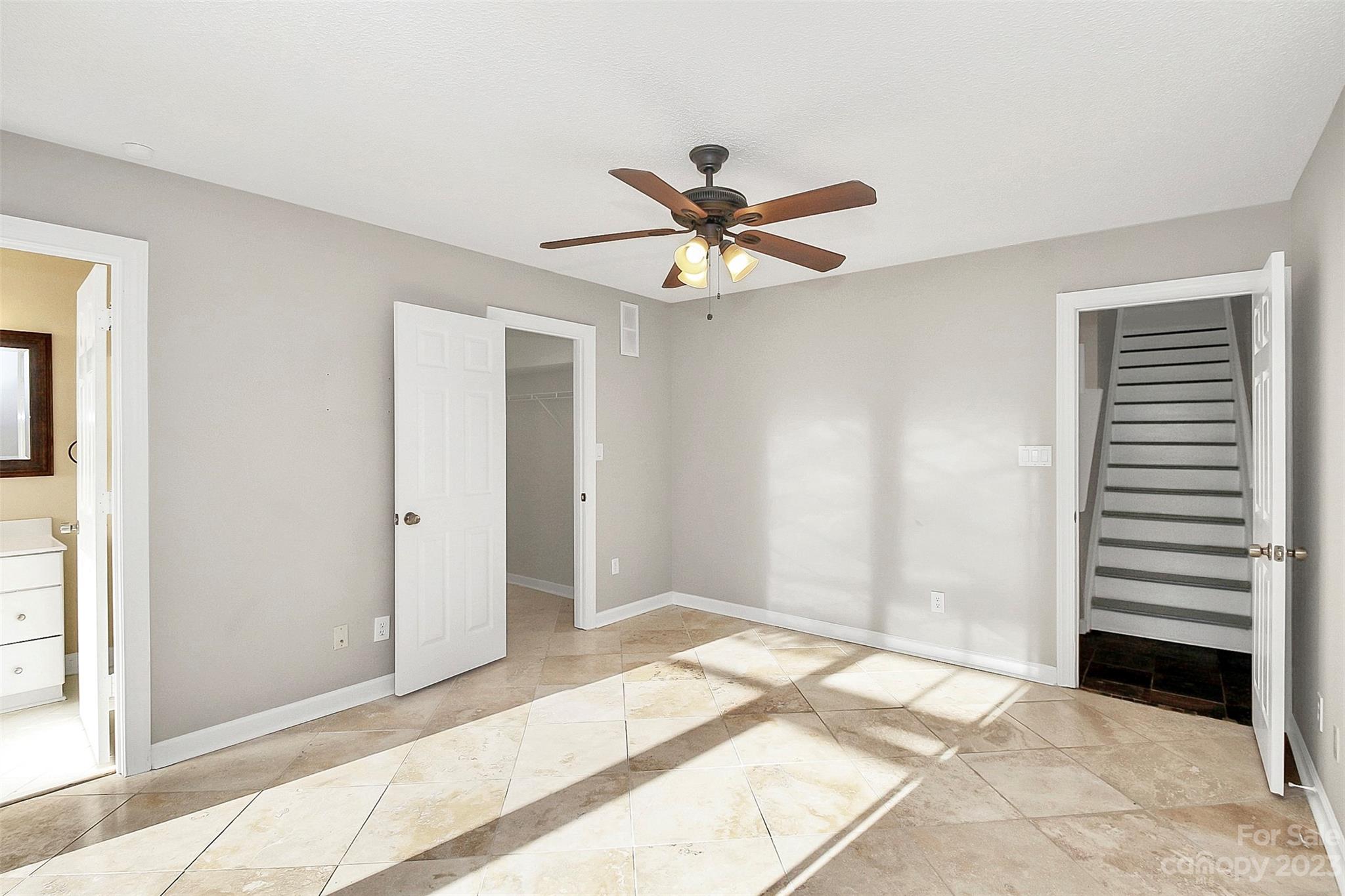 13932 Queens Harbor Road Charlotte, NC 28278 - Photo 7 of 42 a bedroom with a bed and a chandelier fan