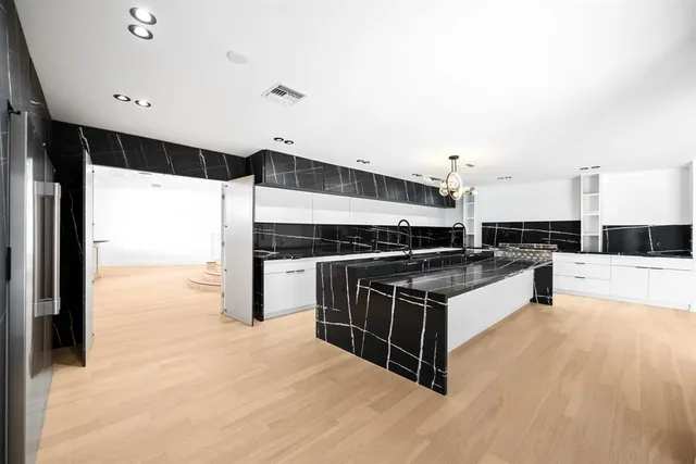 a kitchen with stainless steel appliances kitchen island granite countertop a stove and a refrigerator