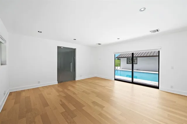 a view of an empty room with wooden floor