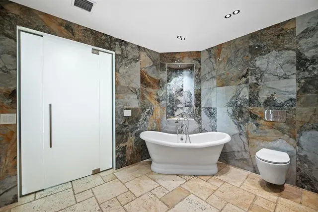 a spacious bathroom with a bathtub and toilet