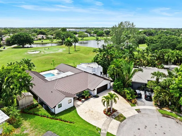 an aerial view of a house with outdoor space and trees all around