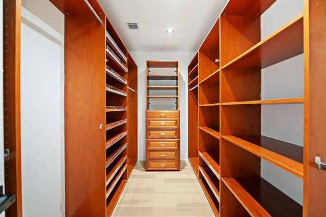 a view of walk in closet with empty racks