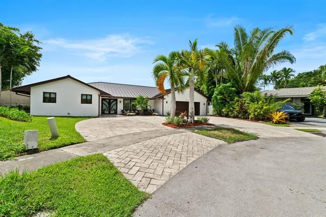 a view of a house with a yard and potted plants