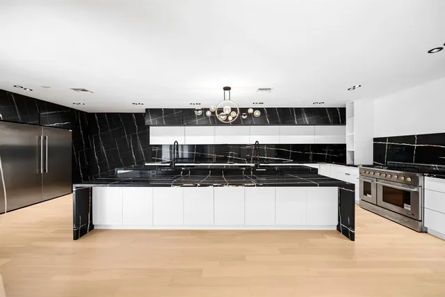 a kitchen with stainless steel appliances and view of living room