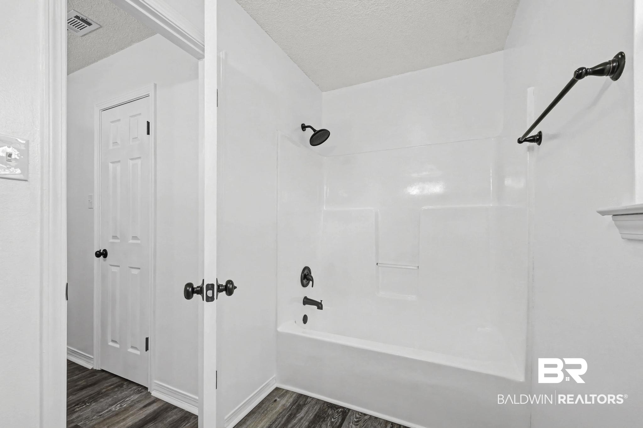 2776 Santa Rosa Circle Lillian, AL 36549 - Photo 21 of 48 Bathroom featuring a textured ceiling, shower / washtub combination, and dark wood-style flooring